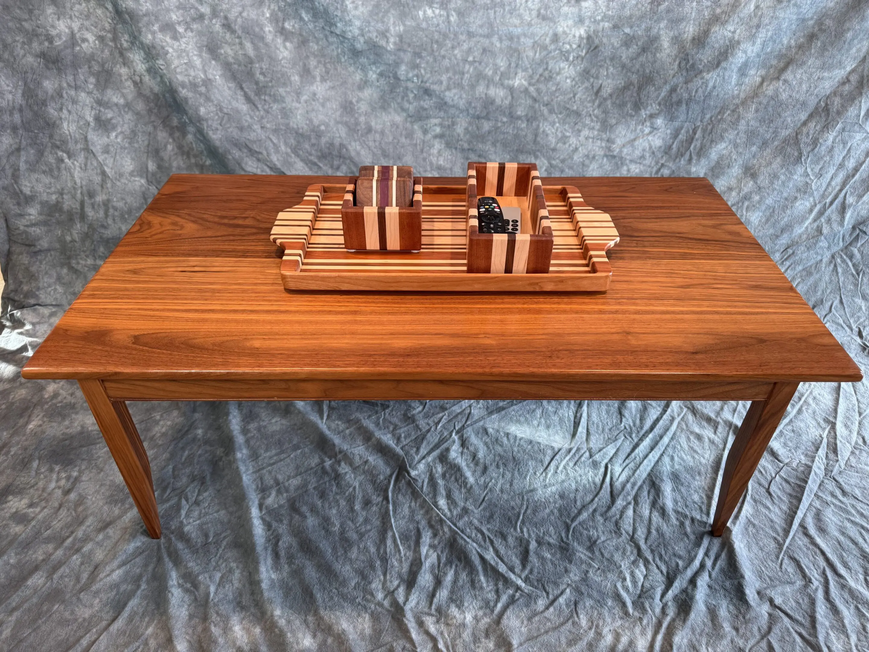 Wooden table with a miniature wooden ship model on top.